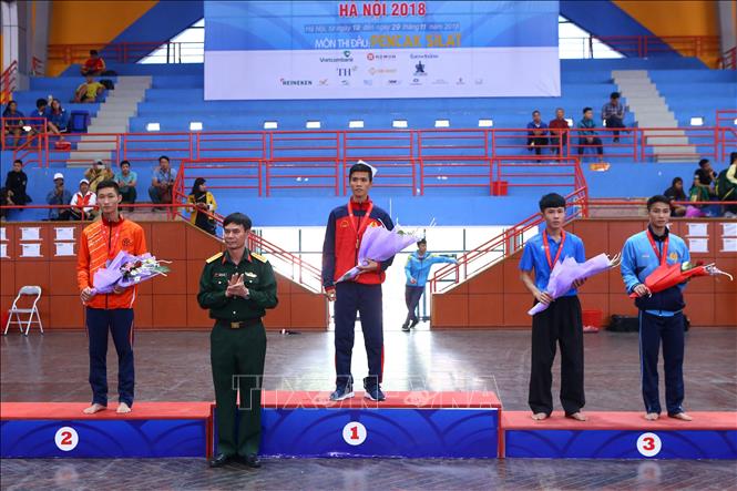 Trong ảnh: Ban tổ chức trao giải nội dung Đối kháng nam hạng 50kg: Lê Quốc Sơn (Quân đội, HCV), Trần Đại Huynh (Hà Nội, HCB), Phùng Minh Hoàn (CAND, HCĐ) và Bùi Văn Thống (Phú Thọ, HCĐ). Ảnh Minh Quyết – TTXVN