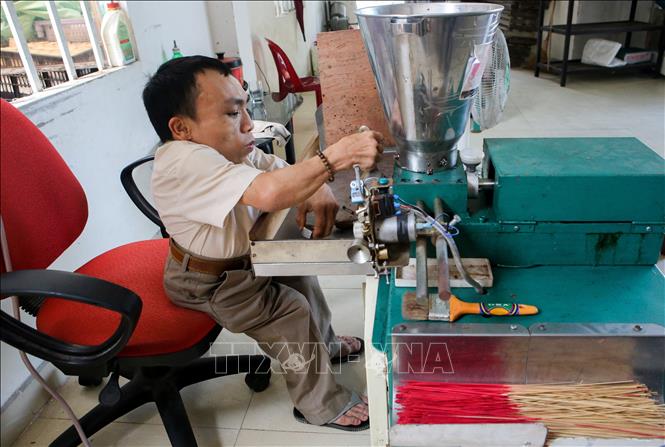 Trong ảnh: Từ sáng sớm thầy Phương đã đến trung tâm để canh chỉnh máy móc, chuẩn bị nguyên liệu cho các em đến làm việc. Ảnh: Trần Lê Lâm - TTXVN