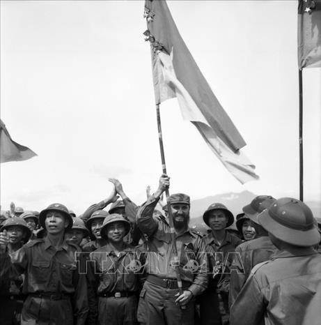 Trong ảnh: Lãnh tụ Cuba Fidel Castro phất cao lá cờ truyền thống của Đoàn Khe Sanh, Quân giải phóng Trị Thiên-Huế khi đến thăm vùng giải phóng miền Nam Việt Nam thuộc tỉnh Quảng Trị, ngày 15/9/1973. Ảnh: TTXVN