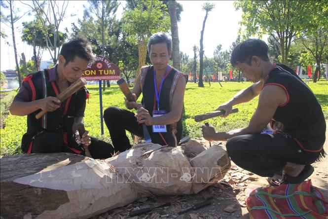 Trong ảnh: Nghệ nhân trình diễn tạc tượng gỗ dân gian. Ảnh: Hồng Điệp - TTXVN