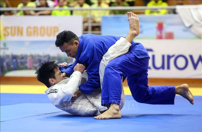 Trong ảnh: Trận bán kết nội dung nam dưới 60 kg giữa VĐV Phan Vũ Nam (Công an nhân dân, áo trắng) và VĐV Trần Hữu Tạo (Bình Thuận, áo xanh). Ảnh: Thành Đạt – TTXVN
