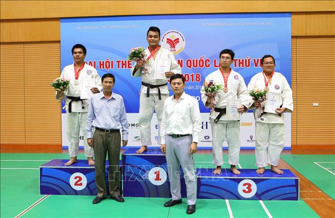 Trong ảnh: Trao giải nội dung nam dưới 100 kg cho các VĐV: Nguyễn Hoàng Dương (HCM, HCV), Lưu Minh Thiện (Bình Dương, HCB), Lê Đình Văn (Quân đội, HCĐ) và Đinh Hữu Lợi (Thanh Hoá, HCĐ). Ảnh: Thành Đạt – TTXVN

