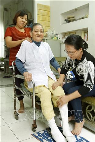 Trong ảnh: Cộng tác viên dân số hỗ trợ cộng đồng chăm sóc người cao tuổi có hoàn cảnh đặc biệt khó khăn tại quận Hải Châu (Đà Nẵng). Ảnh: Dương Ngọc - TTXVN