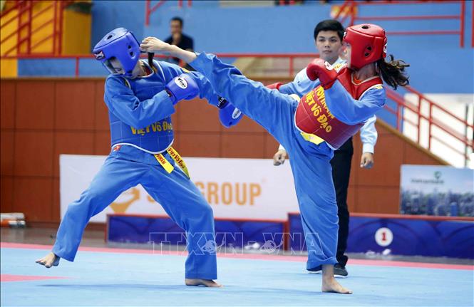 Trong ảnh: VĐV Phạm Thị Kiều Giang, đoàn Bến Tre (giáp đỏ) giành chiến thắng trước VĐV Trương Thị Út, đoàn Quân đội (giáp xanh) với tỷ số 5-1 ở nội dung đối kháng nữ hạng 51 kg. Ảnh: Quang Quyết - TTXVN