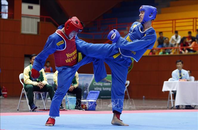 Trong ảnh: VĐV Đỗ Lý Minh Toàn, đoàn Thành phố Hồ Chí Minh (giáp đỏ) xuất sắc vượt qua VĐV Lý Chính Đại, đoàn Phú Yên (giáp xanh) ở nội dung đối kháng nam hạng 64 kg. Ảnh: Quang Quyết - TTXVN