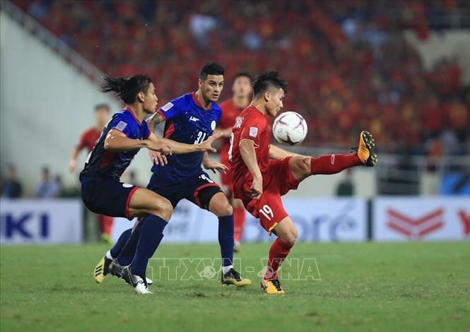 Trong ảnh: Cầu thủ Quang Hải nỗ lực đi bóng vượt qua cầu thủ đối phương. Ảnh: Trọng Đạt - TTXVN