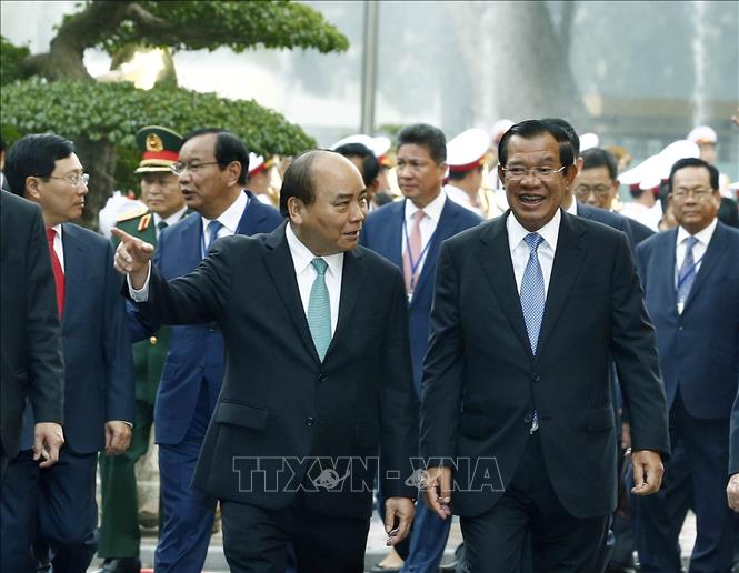 Trong ảnh: Thủ tướng Nguyễn Xuân Phúc nói chuyện thân mật với Thủ tướng Campuchia Samdech Techo Hun Sen trên đường đến Trụ sở Chính phủ để hội đàm. Ảnh: Thống Nhất – TTXVN