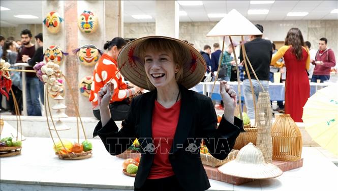 Trong ảnh: Cô gái Nga thích thú khi đội thử chiếc nón Việt Nam tại ngày hội. Ảnh:  Tâm Hằng-Pv TTXVN tại Liên bang Nga                              