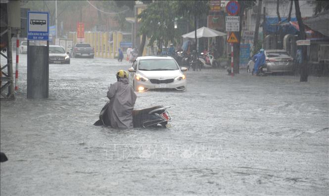Trong ảnh: Nhiều tuyến đường trên địa bàn thành phố Đà Nẵng ngập chìm trong nước làm nhiều xe máy, ô tô bị chết máy, giao thông đi lại rất khó khăn. Ảnh: Đinh Văn Nhiều-TTXVN