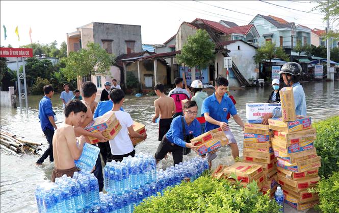 Trong ảnh: Nhóm từ thiện vận chuyển mì tôm và nước lọc cho người dân xã Tam An, huyện Phú Ninh bị ngập sâu trong nước. Ảnh: Đỗ Văn Trưởng - TTXVN