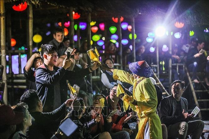 Photo: Card deliverer Phan Van Phong rewards a group with a yellow flag, which signify this group has one card match with that of the game singers. VNA Photo: Trọng Đạt
