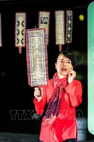 Photo: A game singer sings the meaning of a card while presenting it to the audience for comparison. VNA Photo: Trọng Đạt