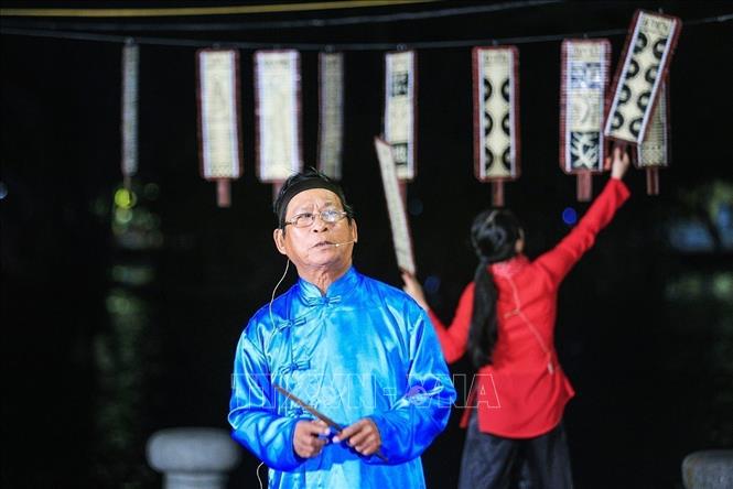 Photo: Game singer and artisan Nguyen Dang sings the meanings of the playing cards and brings laughter to the audience through his ways of singing. VNA Photo: Trọng Đạt