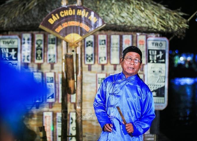 Photo: Game singer and artisan Nguyen Dang sings the meaning of the playing cards and brings laughter to the audience through his ways of singing. VNA Photo: Trọng Đạt
