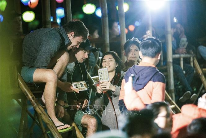 Photo: Foreign tourists learn the meaning of the playing cards while participating in a Bai Choi performance in Hoi An ancient town, Quang Nam province. VNA Photo: Trọng Đạt
