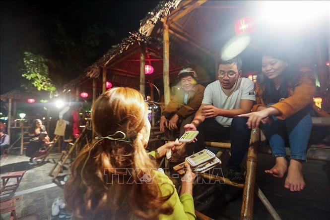 Photo: The game singer distributes playing cards to players prior to the start of Bai Choi performance. VNA Photo: Trọng Đạt