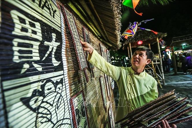 Photo: A game singer places the playing cards in the central house. VNA Photo: Trọng Đạt
