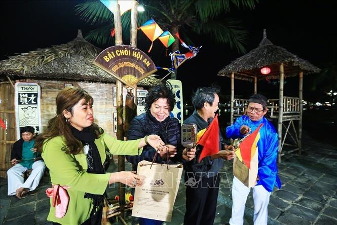 Photo: The Bai Choi singers present the prizes to winners of the game. The winner is decided when they have three same cards with the cards held by the game singers, at which point they achieve a red flag. VNA Photo: Trọng Đạt
