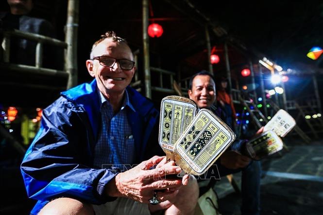 Photo: A foreign tourist enjoys Bai Choi performance in Hoi An ancient town, Quang Nam province. VNA Photo: Trọng Đạt
