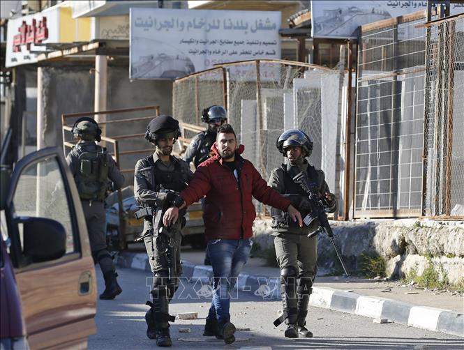 Trong ảnh: Các lực lượng Israel bắt giữ một người Palestine xung đột với binh sĩ Israel sau vụ tấn công của các tay súng Palestine ở ngoại ô Givat Asaf, phía đông bắc thành phố Ramallah ngày 13/12/2018. Ảnh: AFP/ TTXVN