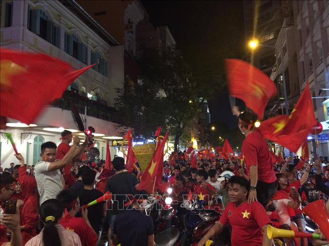 Trong ảnh: Cổ động viên ăn mừng Đội tuyển bóng đá Việt Nam giành cúp vô địch tại TP Hồ Chí Minh. Ảnh:Xuân Dự-TTXVN