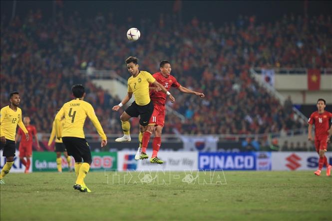 Photo: A fight for the ball between Vietnamese players (red T-shirt) and Malaysian rivals (yellow T-shirt) during the match. VNA Photo