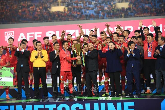 Photo: Prime Minister Nguyen Xuan Phuc hands over the AFF Suzuki Cup to the Vietnamese national team. VNA Photo