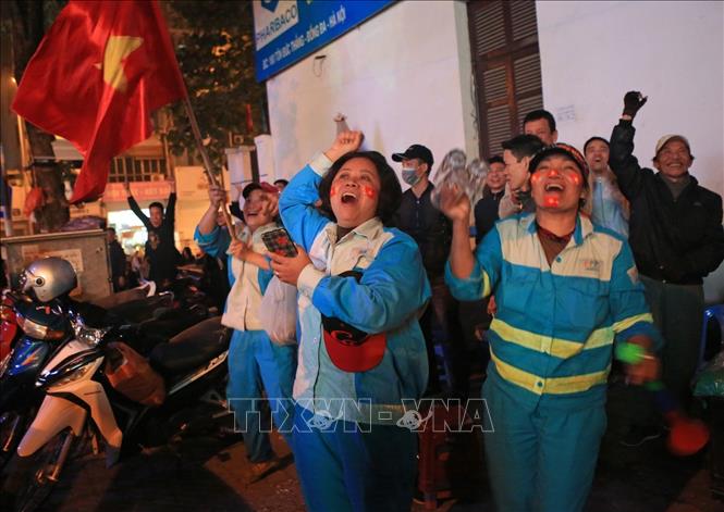Trong ảnh: Những nữ công nhân Công ty Môi trường Đô thị Hà Nội vui mừng trước chiến thắng của đội tuyển Việt Nam. Ảnh: Ngọc Hà- TTXVN