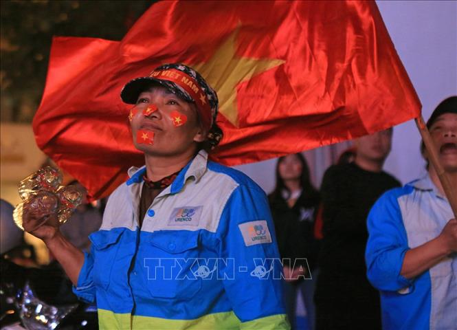Trong ảnh: Chị Hà - nữ công nhân Công ty Môi trường Đô thị Hà Nội nghẹn ngào trước chiến thắng của đội tuyển Việt Nam. Ảnh: Ngọc Hà- TTXVN