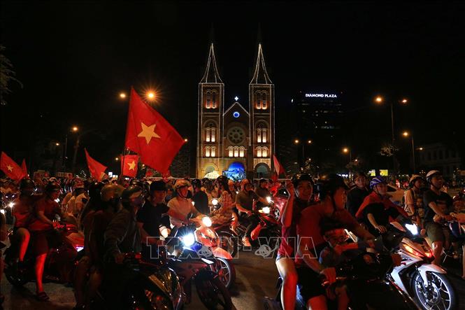Trong ảnh: Người hâm mộ Thành phố Hồ Chí Minh vui mừng sau trận thắng của đội thuyển Việt Nam trước đội tuyển Malaysia 1 - 0 và giành chức vô địch Giải bóng đá Đông Nam Á năm 2018 (AFF Suzuki Cup 2018). 
Ảnh: Thanh Vũ - TTXVN 