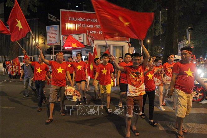 Trong ảnh: Người hâm mộ Thành phố Hồ Chí Minh vui mừng sau trận thắng của đội thuyển Việt Nam trước đội tuyển Malaysia 1 - 0 và giành chức vô địch Giải bóng đá Đông Nam Á năm 2018 (AFF Suzuki Cup 2018). 
Ảnh: Thanh Vũ - TTXVN