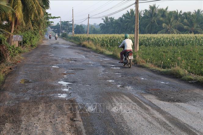 Trong ảnh: Đường dẫn vào phà Bình Ninh phía bờ Bắc lỗ chỗ ổ gà. Ảnh: Minh Trí - TTXVN