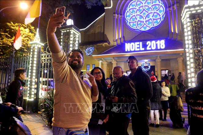 Trong ảnh: Du khách quốc tế đón Giáng sinh. Ảnh: Thành Đạt – TTXVN
