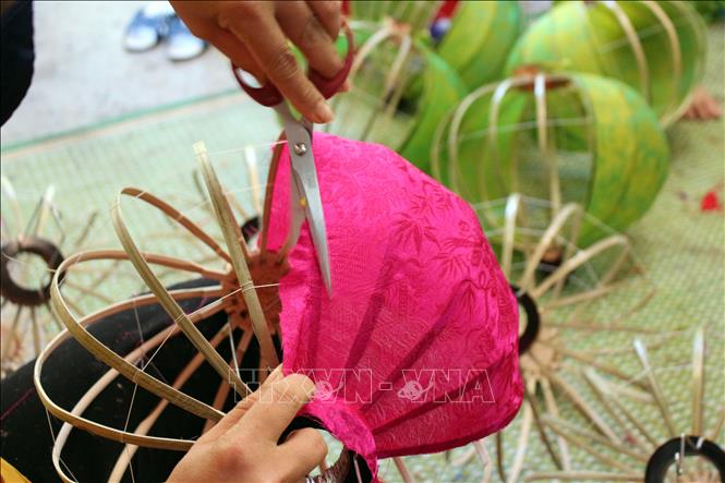 Trong ảnh: Người thợ luôn tỉ mỉ trong từng công đoạn để làm ra những chiếc đèn lồng. Ảnh: Đỗ Trưởng - TTXVN