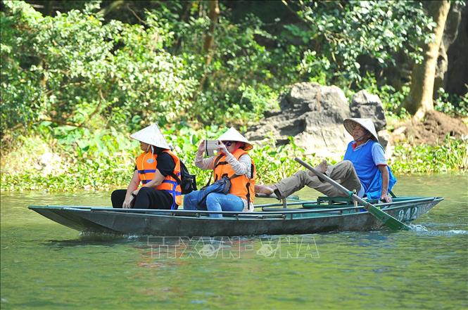 Trong ảnh: Chèo đò bằng chân đưa khách du lịch đi tham quan tại khu du lịch Tam Cốc. Ảnh: Minh Đức - TTXVN

