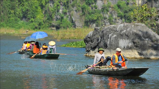 Trong ảnh: Chèo đò bằng chân đưa khách du lịch đi tham quan tại khu du lịch Tam Cốc. Ảnh: Minh Đức - TTXVN


