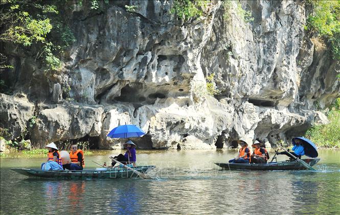 Trong ảnh: Chèo đò bằng chân đưa khách du lịch đi tham quan tại khu du lịch Tam Cốc. Ảnh: Minh Đức - TTXVN


