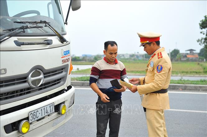 Lực lượng Cảnh sát giao thông kiểm tra giấy phép lái xe trên tuyến quốc lộ 1A. Ảnh: Minh Đức - TTXVN