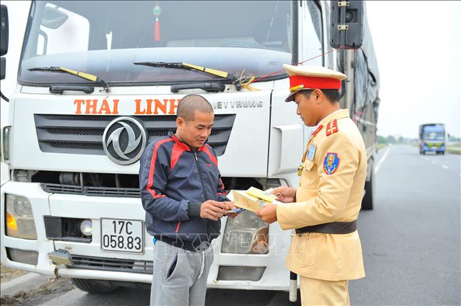 Lực lượng Cảnh sát giao thông kiểm tra giấy phép lái xe trên tuyến quốc lộ 1A. Ảnh: Minh Đức - TTXVN