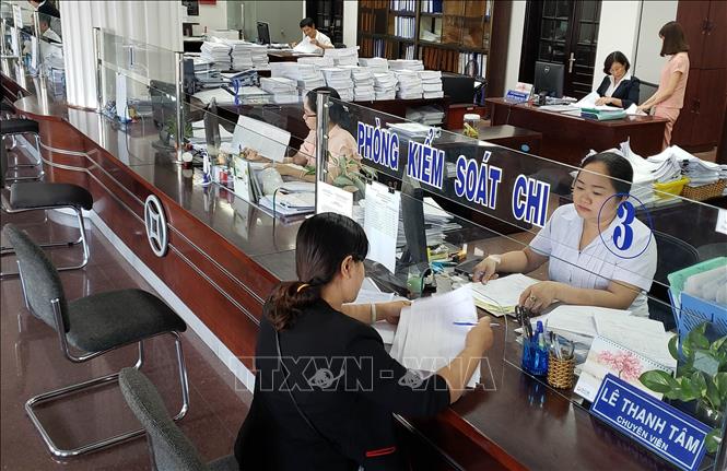 Trong ảnh: Triển khai thành công mô hình “một cửa, một giao dịch viên” với quy trình đơn giản, thuận tiện, nâng cao vai trò, trách nhiệm của công chức kiểm soát chi, hạn chế được tình trạng sách nhiễu, gây khó khăn cho khách hàng thông qua cơ chế trách nhiệm đầy đủ và chế tài xử lý rõ ràng, tạo điều kiện để ứng dụng công nghệ thông tin đối với giao dịch dịch vụ công trong hệ thống KBNN. Ảnh chụp tại KBNN tỉnh Bến Tre. Ảnh: Hoàng Hùng – TTXVN