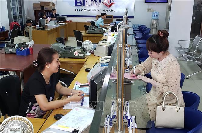 Trong ảnh: KBNN áp dụng đa dạng các hình thức thu nộp NSNN qua ngân hàng, qua thiết bị chấp nhận thẻ POS, quầy rút tiền tự động ATM, Internet, thu phạt vi phạm hành chính qua bưu điện. Ảnh chụp tại quầy Thu hộ ngân sách Nhà nước tại Ngân hàng TMCP Đầu tư và Phát triển Việt Nam (BIDV) chi nhánh Tiền Giang. Ảnh: Hoàng Hùng - TTXVN