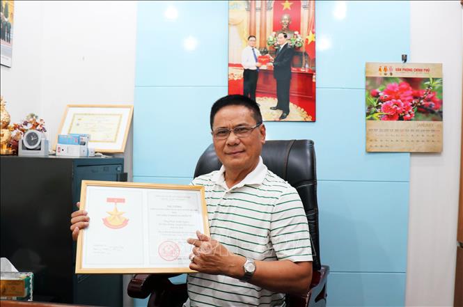 Trong ảnh: Ông Phan Xuân Nghĩa, Trưởng Ban liên lạc thường trực Bộ đội Biên phòng giúp bạn Campuchia tại Thành phố Hồ Chí Minh cùng với Giấy chứng nhận Huy hiệu Vì nghĩa vụ quốc tế do Thủ tướng Chính phủ tặng. Ảnh: Xuân Khu-TTXVN