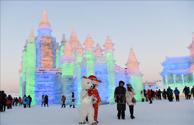 Trong ảnh: Du khách ngắm các tác phẩm điêu khắc băng trưng bày tại Lễ hội băng đăng quốc tế  ở Cáp Nhĩ Tân, Trung Quốc. Ảnh: THX/TTXVN
