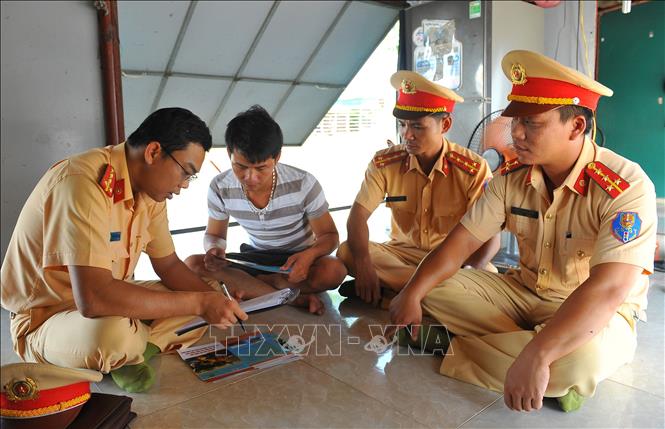 Trong ảnh: Cán bộ Đội Cảnh sát đường thủy tuyên truyền pháp luật cho chủ tàu. Ảnh: Minh Đức - TTXVN