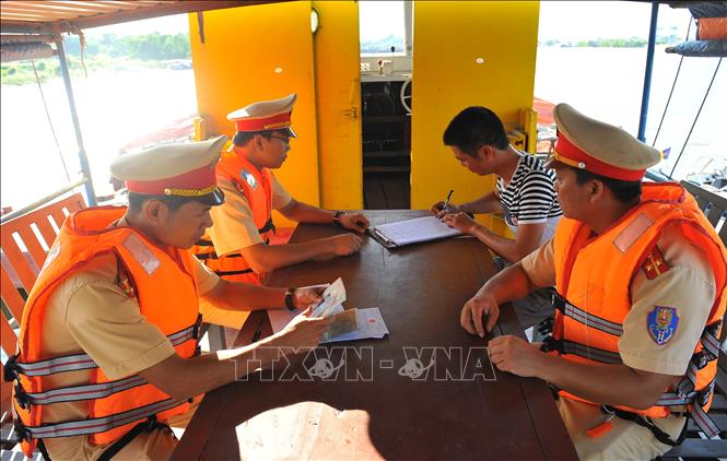Trong ảnh: Cán bộ Đội Cảnh sát đường thủy kiểm tra giấy phép của chủ tàu. Ảnh: Minh Đức - TTXVN
