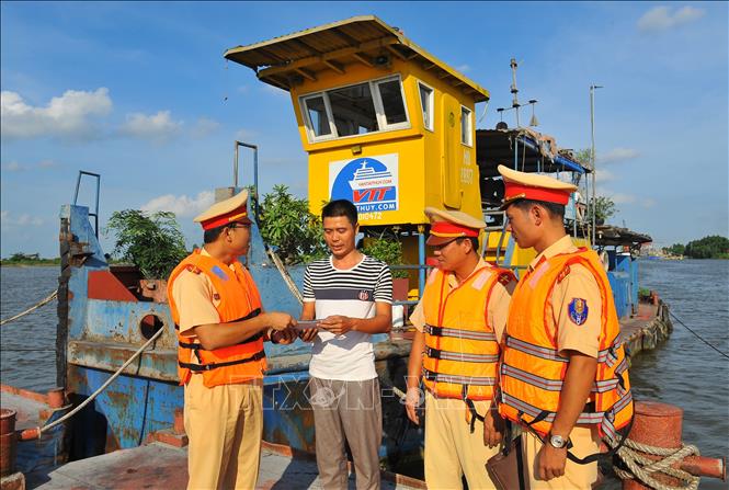 Trong ảnh: Cán bộ Đội Cảnh sát đường thủy tuyên truyền pháp luật cho chủ tàu. Ảnh: Minh Đức - TTXVN