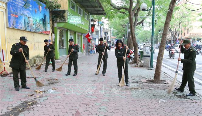 Trong ảnh: Đoàn viên thanh niên Công an Hà Nội và học sinh Trường THPT Việt Đức, quận Hoàn Kiếm tham gia làm vệ sinh môi trường. Ảnh: Doãn Tấn – TTXVN