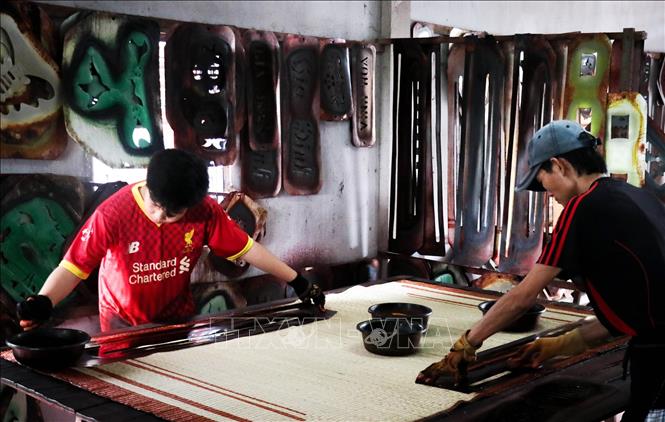 Trong ảnh: Công đoạn in hình lên chiếu sau khi đã dệt xong. Ảnh: Nam Thái - TTXVN