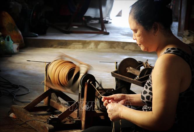 Trong ảnh: Công đoạn xe vuốt, cuộn sợi trước khi đem đi dệt. Ảnh: Nam Thái - TTXVN