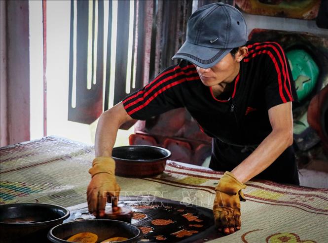 Trong ảnh: Công đoạn in hình lên chiếu sau khi đã dệt xong. Ảnh: Nam Thái - TTXVN